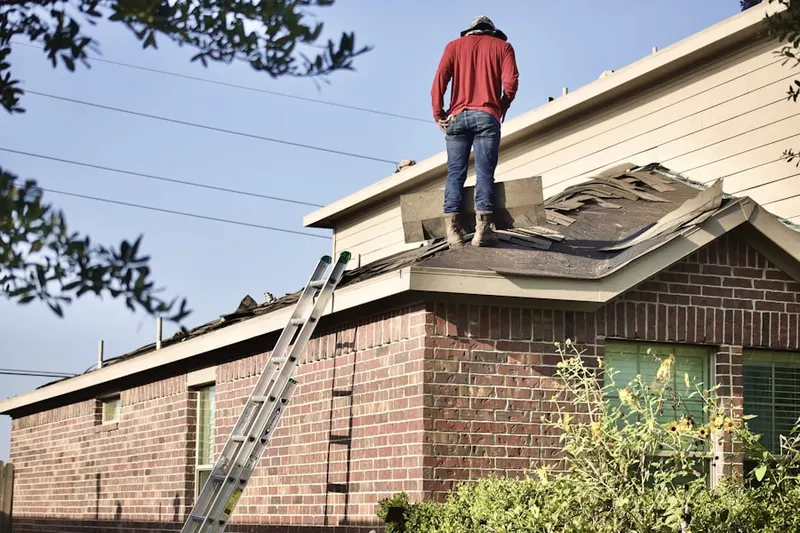 Professional roofer working on a residential roof in Clay Island